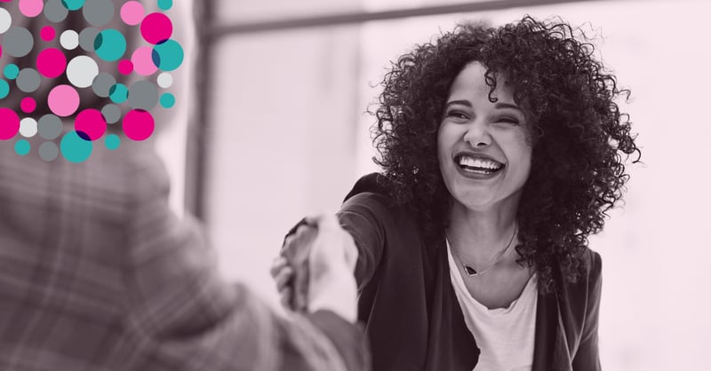 business woman smiling whilst shaking hands
